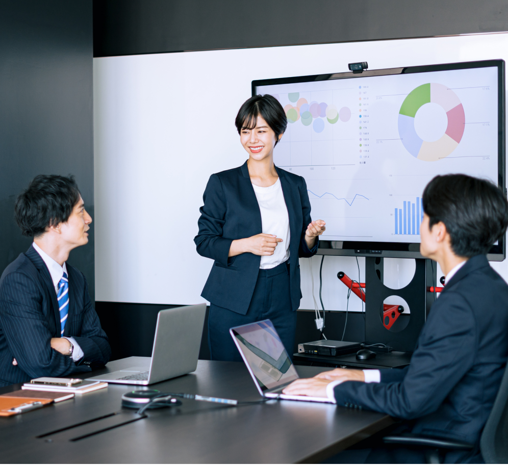 グラフを前にビジネスの未来について議論する3人のビジネスパーソン