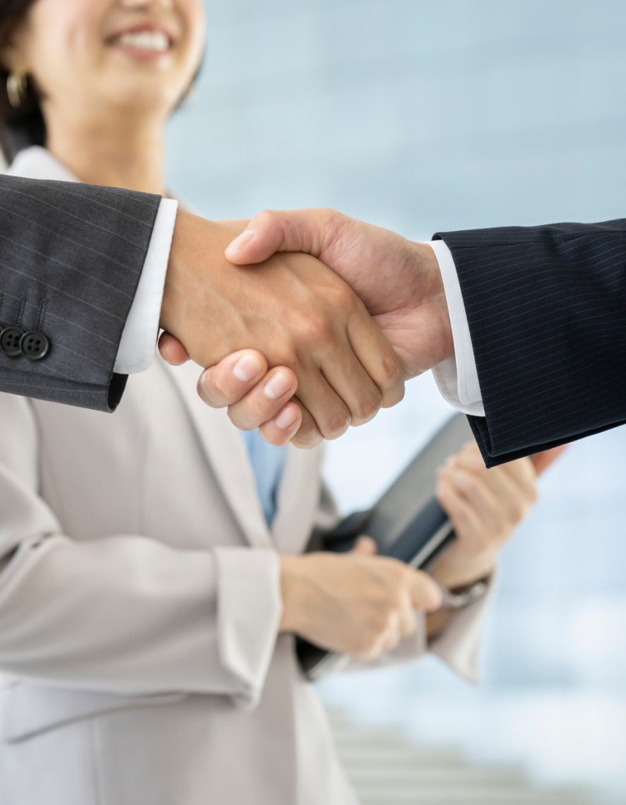 ビジネスシーンで笑顔の女性と男性が握手している様子